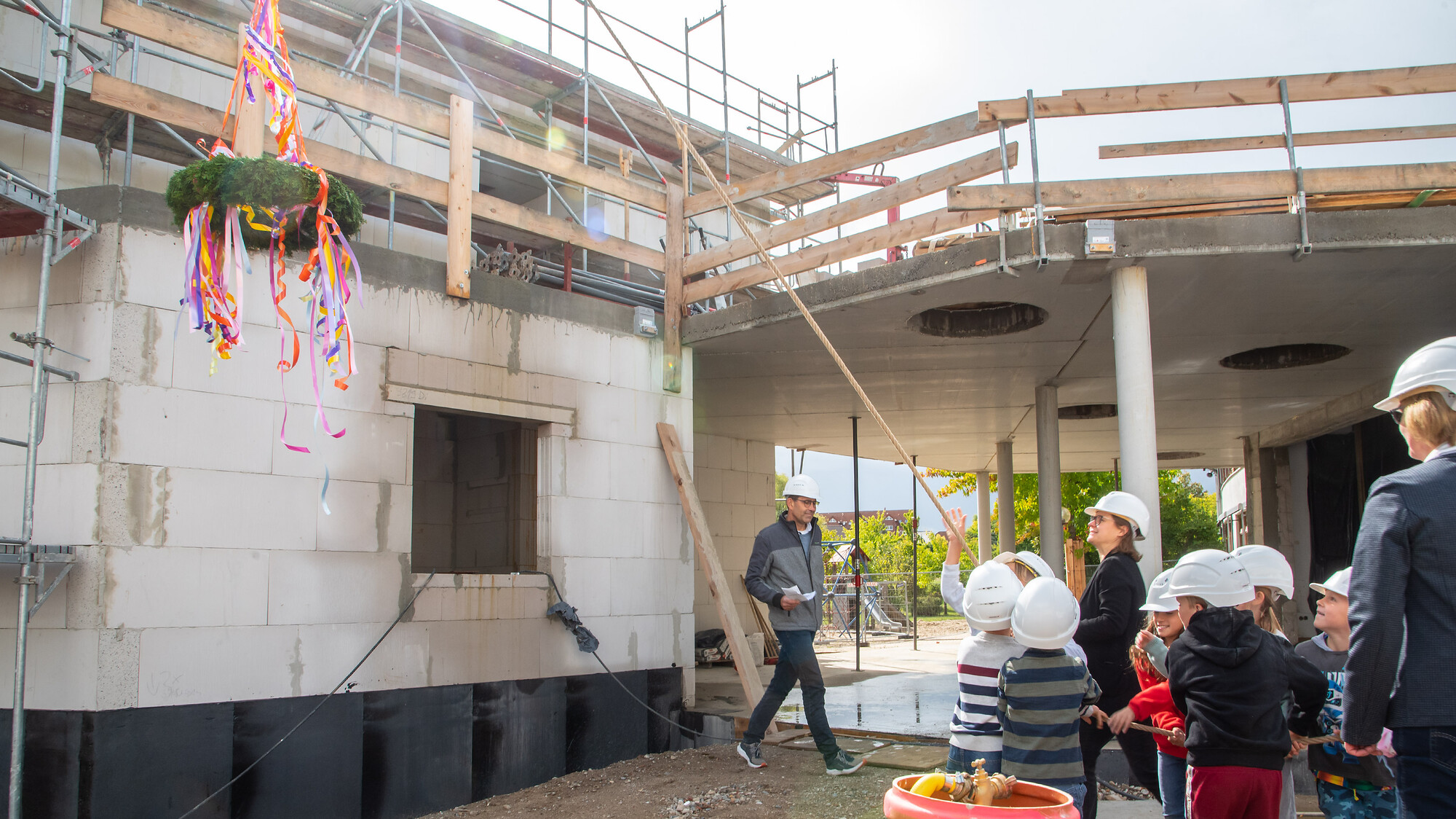 Grundschüler:innen zogen den selbst gefertigten Richtkranz am Käferschul-Anbau in Reislingen hoch.