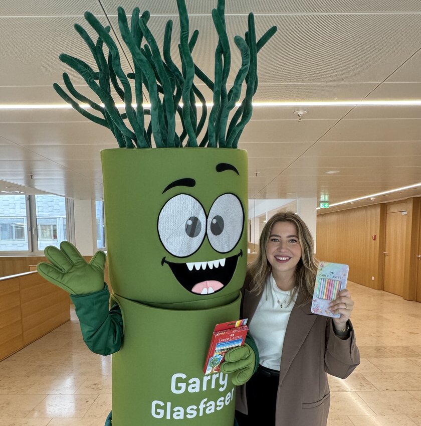 Garry Glasfaser steht mit einer Frau arm in arm. Beide haögten Balstifte in die Kamera.