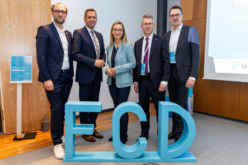 Fünf Personen stehen vor dem Aufsteller " FCD"