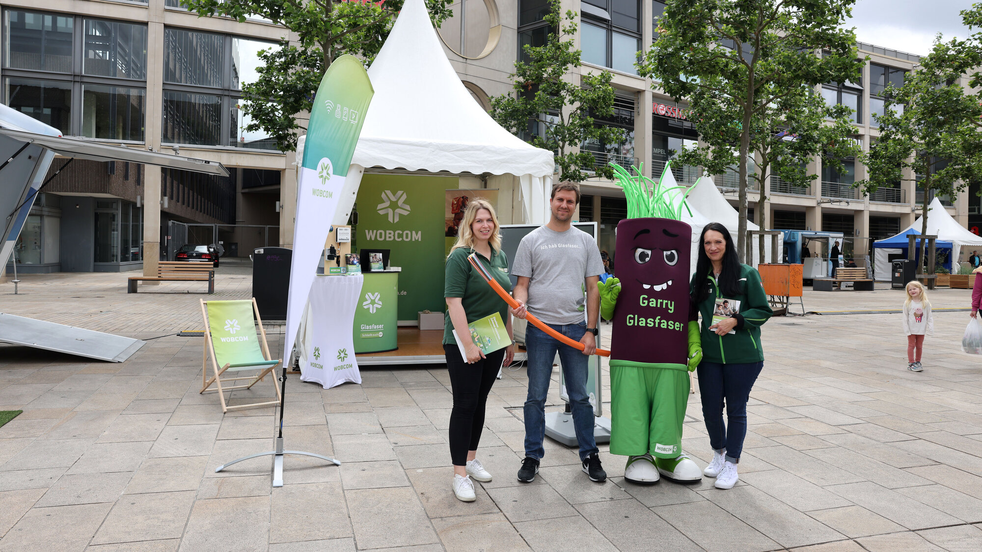 DigiWeek: WOBCOM Mitarbeiterinnen mit Garry Glasfaser am Messestand