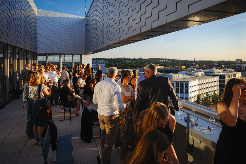 Menschen auf der Dachterrasse während des Sonnenuntergangs